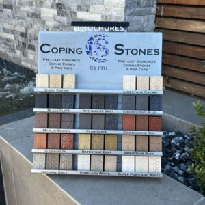 Precast concrete coping stone colour samples including Bathstone Buff, Portland White, Anthracite Grey, Black Slate and Sandstone Buff displayed on a modern garden wall.